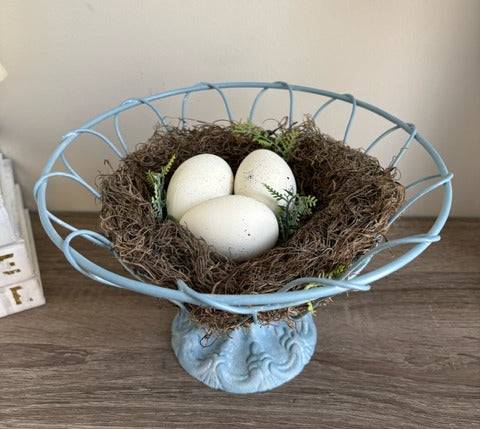 Decorative blue wire basket with a nest and eggs.