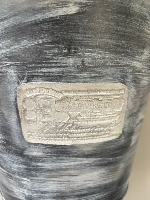Decorative wall basket with a clay label on a textured surface