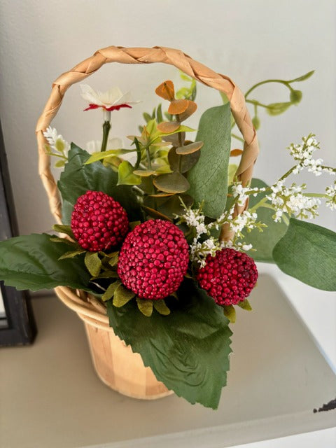 Decorative basket with red raspberries and green leaves 