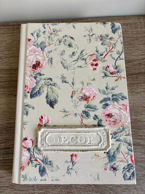 Floral book with 'Decor' label on a wooden surface