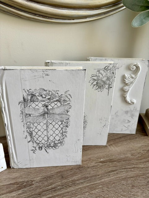 Decorative books with intricate designs on a wooden surface