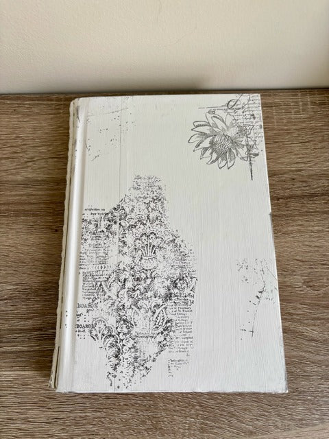 Decorative book with black and white designs on a wooden surface