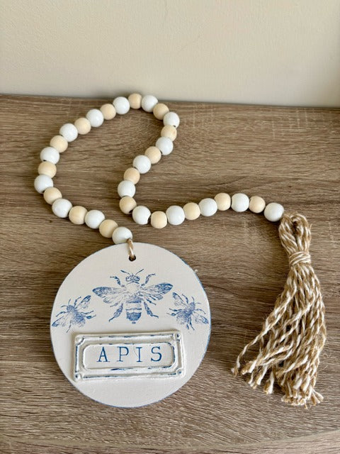 Decorative beaded garland with 'APIS' clay tag and bee design 