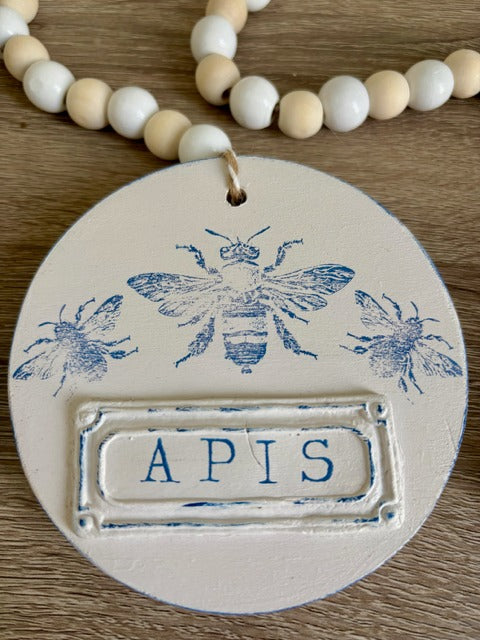 Decorative beaded garland with 'APIS' clay tag and bee design 