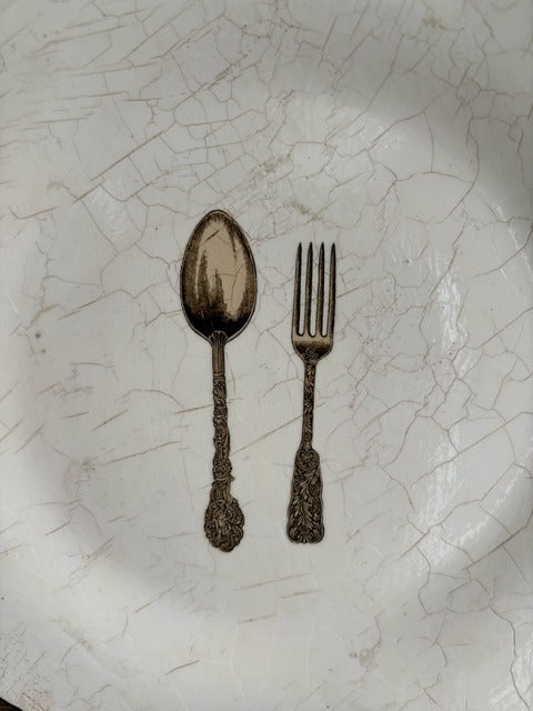 Decorative spoon and fork on a textured white surface