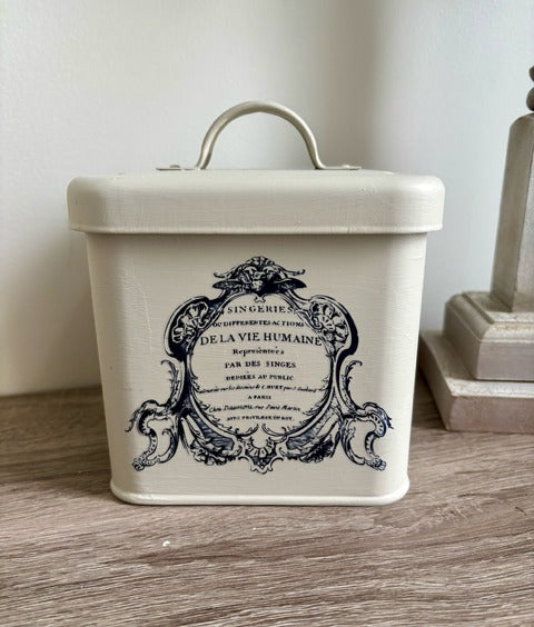 Vintage-style storage canister with decorative lid on a wooden surface
