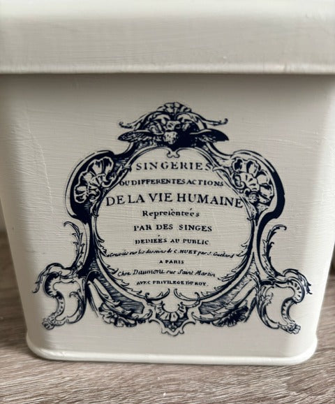 Decorative container with vintage-style black text and design on a white background