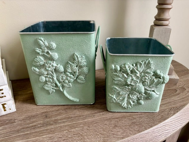 Two green decorative planters with floral designs 