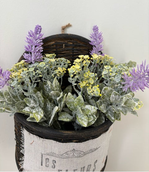 Decorative wall planter with artificial flowers labeled 'Les Fleurs' on a plain background