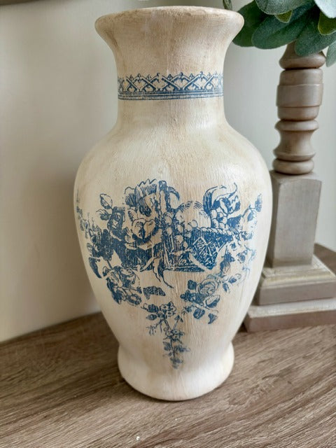 White vase with blue floral patterns on a wooden surface