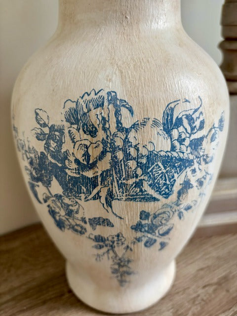 White vase with blue floral patterns on a wooden surface