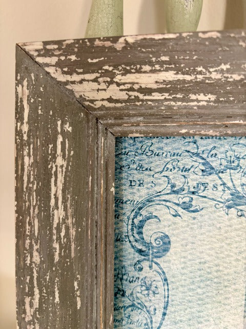 Framed artwork with a rabbit and roses on a textured surface