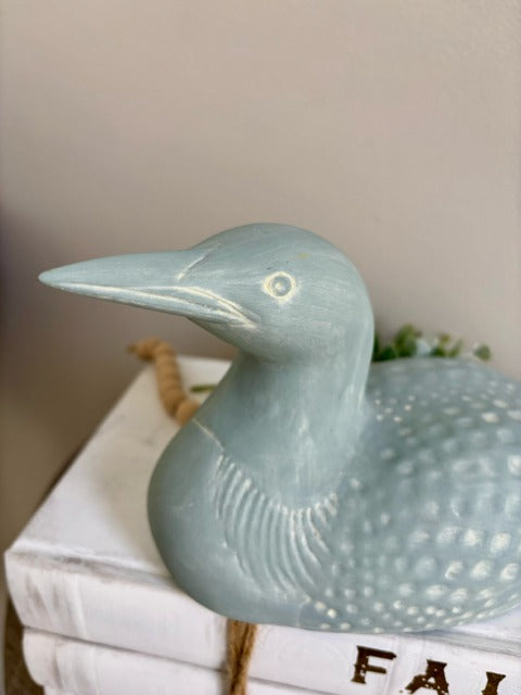 Decorative loon sculpture on a surface with a neutral background