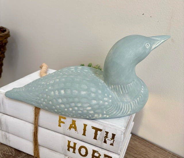 Decorative loon sculpture on a stack of books 