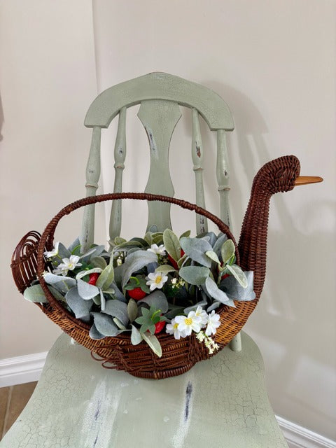 Decorative basket shaped like a swan with flowers and strawberries