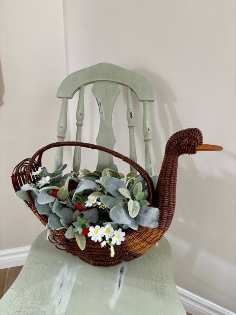 Decorative basket shaped like a swan with flowers and strawberries