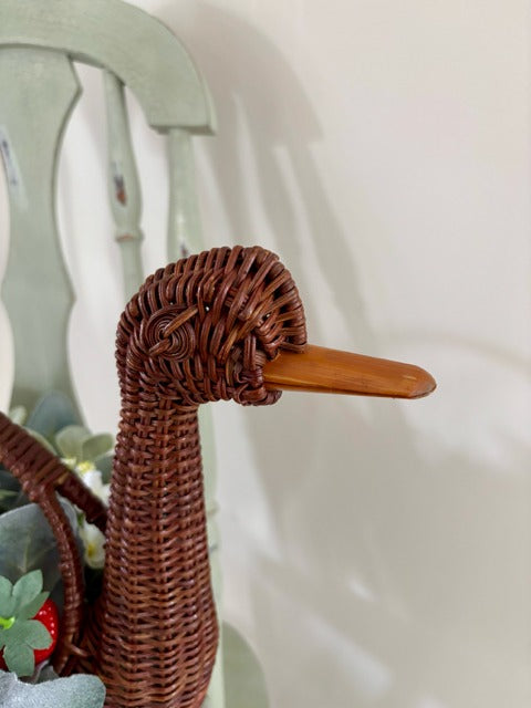 Decorative basket shaped like a swan with flowers and strawberries