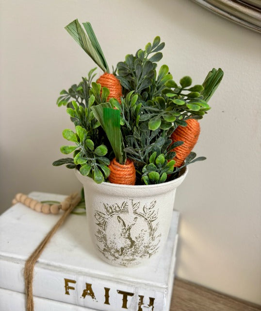 Decorative plant with carrots in a painted pot.