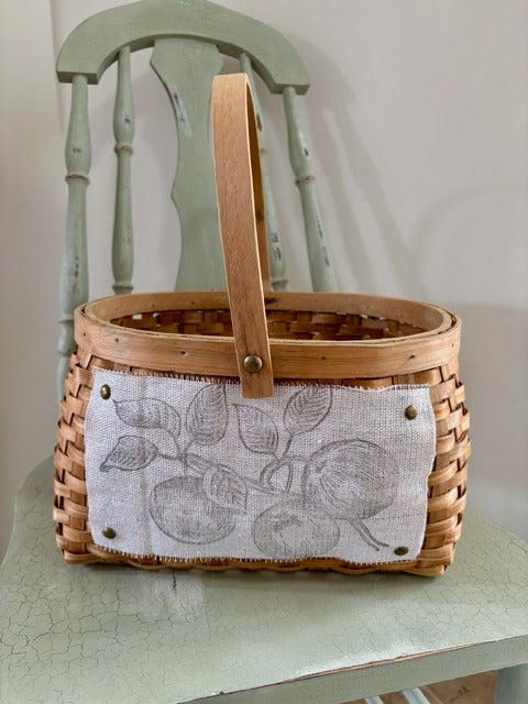 Wooden basket with a fabric cover featuring leaf patterns