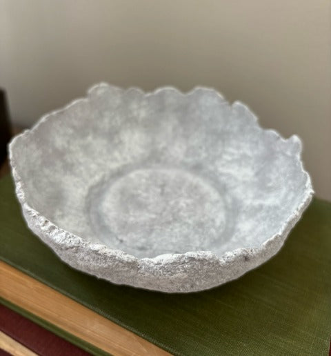 Textured paper mache bowl on a green surface