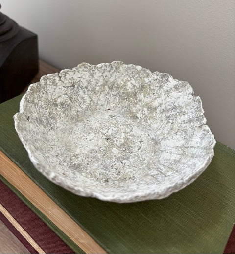 Textured paper mache bowl on a green surface